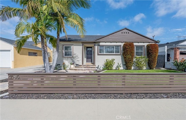 view of front facade with a fenced front yard, a front lawn, and stucco siding