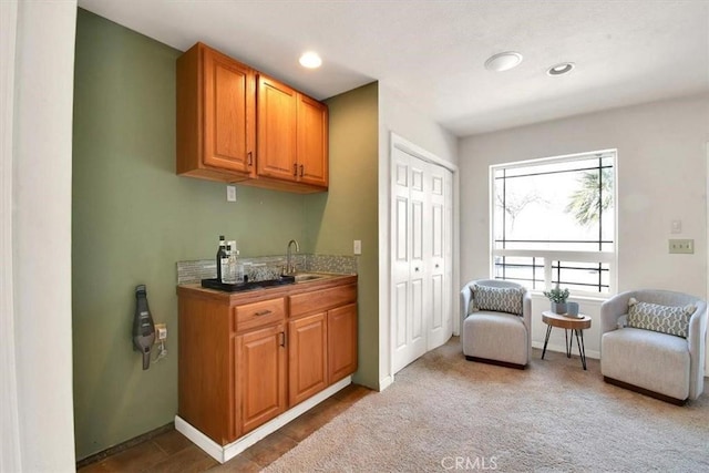 bar with carpet floors, recessed lighting, a sink, and baseboards