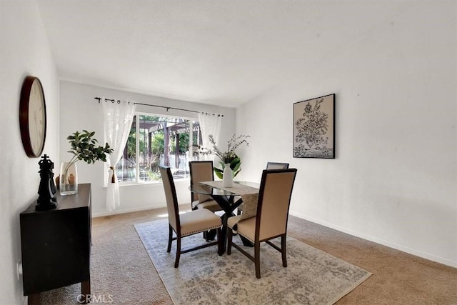 dining space with carpet flooring and baseboards