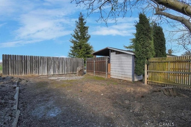 view of yard with a storage shed, an outdoor structure, and a fenced backyard