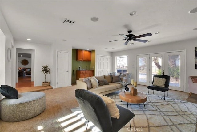 living room with recessed lighting, light colored carpet, visible vents, baseboards, and french doors