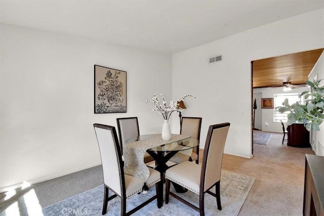 dining room featuring wooden ceiling, visible vents, light carpet, and baseboards