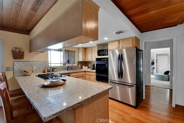 kitchen featuring freestanding refrigerator, a sink, black microwave, gas cooktop, and wooden ceiling