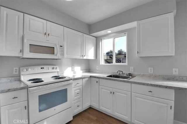 kitchen featuring white appliances, a sink, and white cabinetry