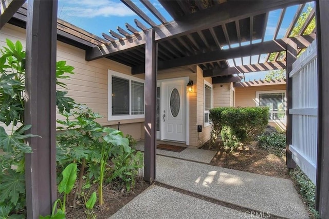 view of exterior entry with a pergola