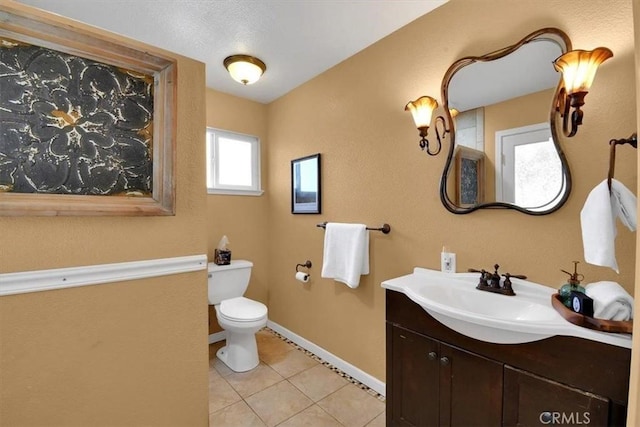 bathroom with baseboards, vanity, toilet, and tile patterned floors