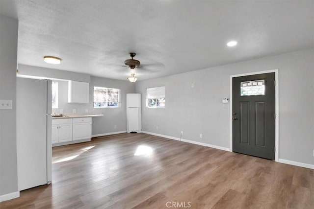 entrance foyer featuring ceiling fan, baseboards, and wood finished floors