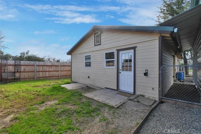 rear view of house with fence and a lawn