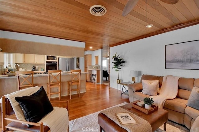 living area featuring wood ceiling, light wood-style flooring, ornamental molding, and visible vents