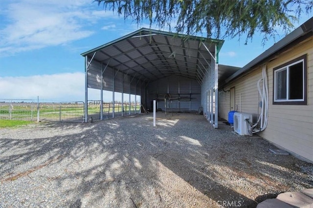 view of vehicle parking featuring a detached carport, fence, driveway, and ac unit