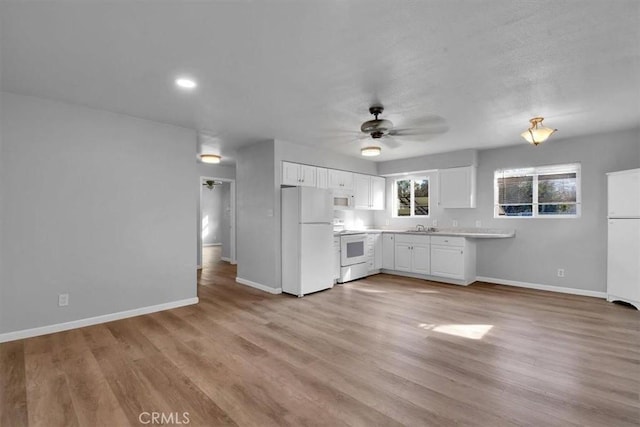 kitchen with light countertops, white cabinets, ceiling fan, white appliances, and baseboards