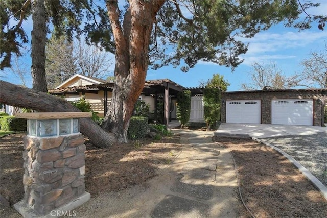 view of front facade with a garage and stone siding