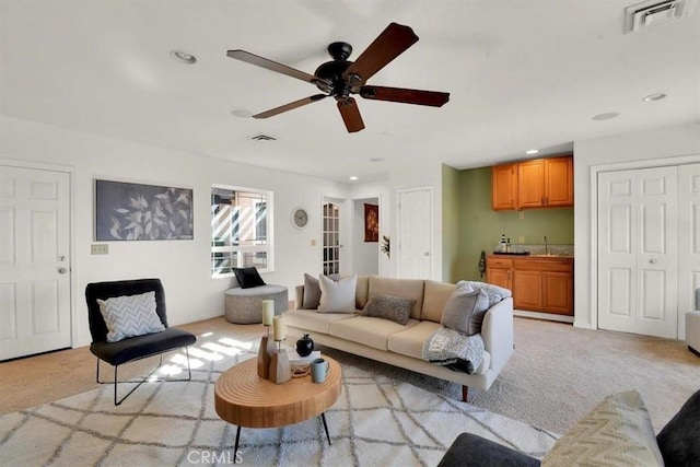 living area with light colored carpet, visible vents, and recessed lighting