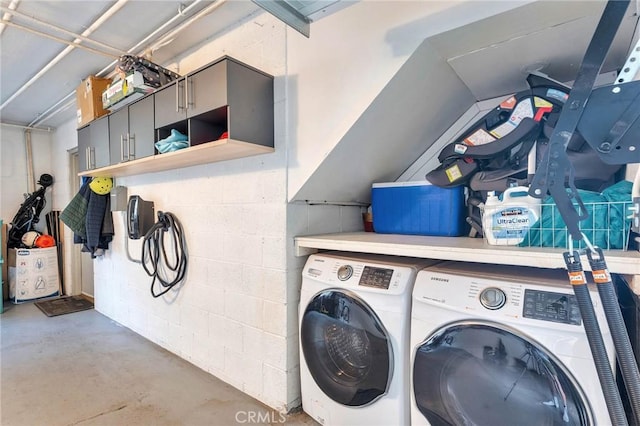 laundry area with concrete block wall, laundry area, and separate washer and dryer