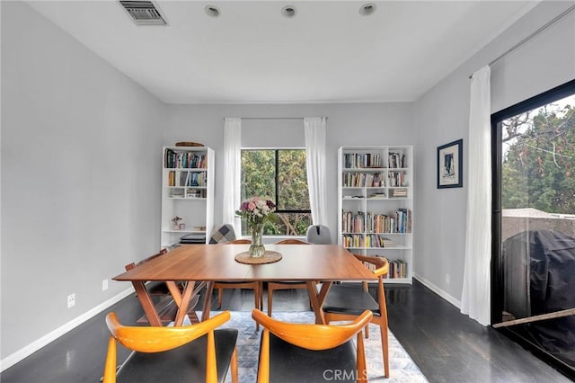 dining space featuring visible vents, baseboards, and wood finished floors