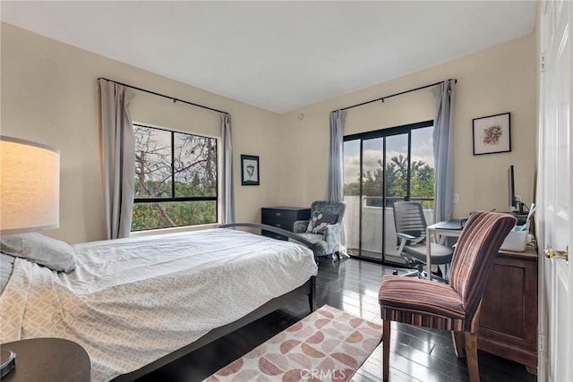 bedroom with access to outside and wood finished floors