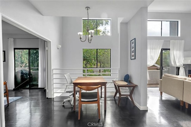 dining room with a towering ceiling, baseboards, and an inviting chandelier