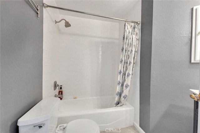 bathroom featuring a textured wall, shower / bath combination with curtain, and toilet