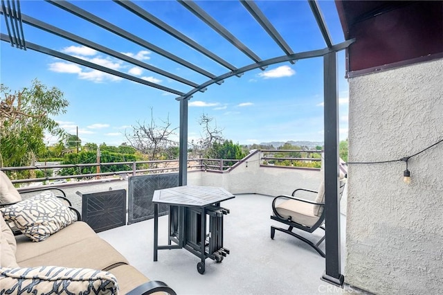 view of patio featuring a balcony and a pergola