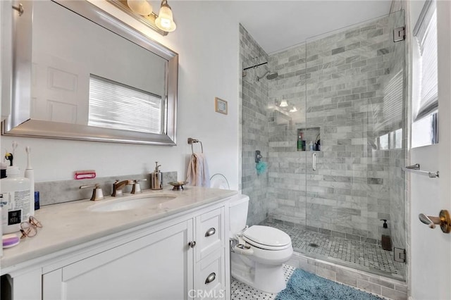 bathroom with toilet, a shower stall, vanity, and tile patterned floors