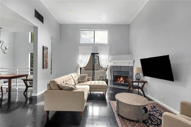 living area with baseboards, visible vents, crown molding, and a high end fireplace