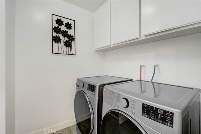 clothes washing area featuring cabinet space, baseboards, and washing machine and clothes dryer