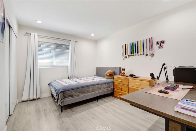 bedroom featuring recessed lighting, a closet, light wood-style flooring, and baseboards