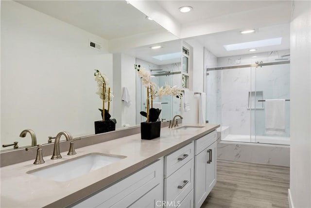 bathroom with a marble finish shower, a skylight, a sink, and visible vents