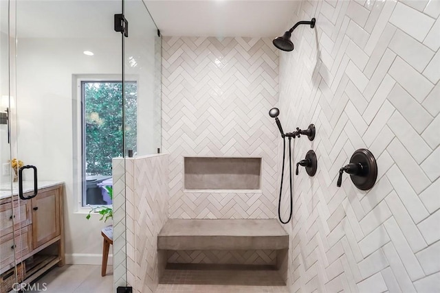 bathroom with baseboards, tiled shower, and tile patterned floors