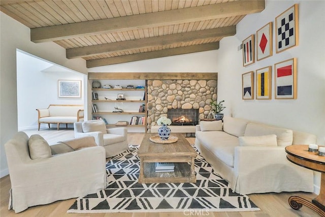 living area with vaulted ceiling with beams, a fireplace, wood finished floors, and wooden ceiling