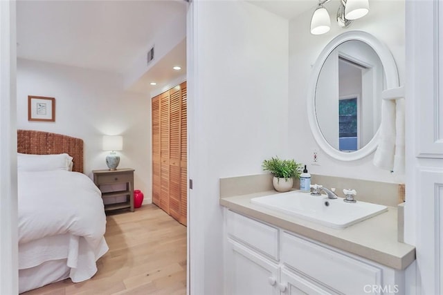 bathroom featuring visible vents, wood finished floors, vanity, and recessed lighting