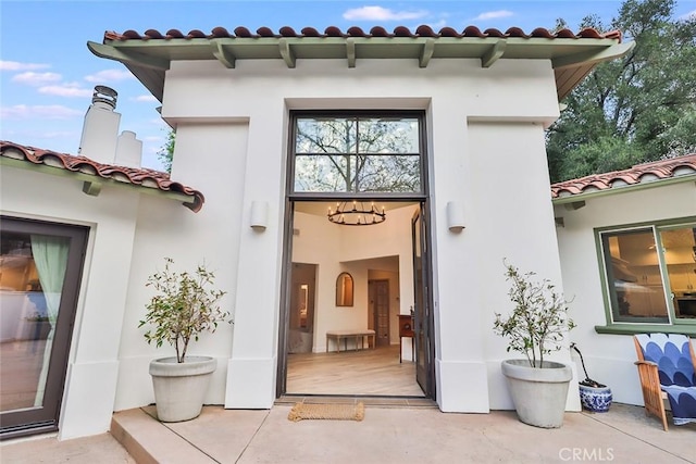 doorway to property with a tiled roof and stucco siding