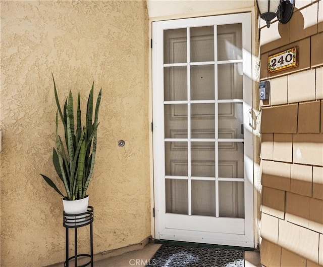 entrance to property with stucco siding