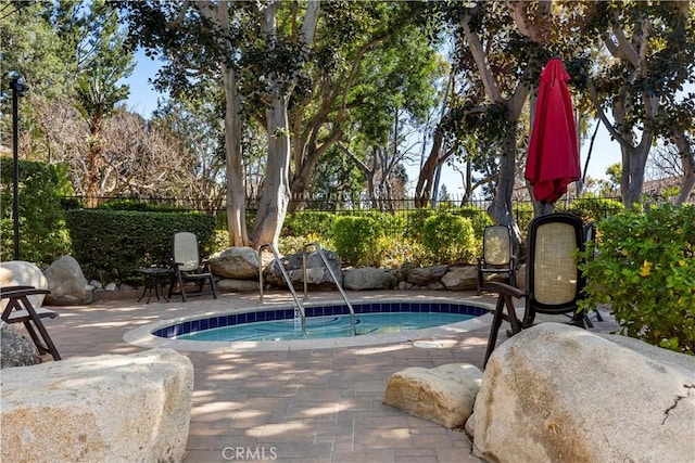 view of swimming pool featuring a patio area, a swimming pool, and fence