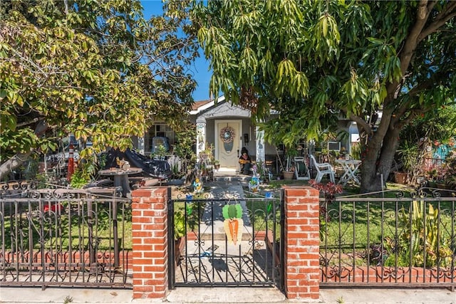 obstructed view of property with a gate, brick siding, and a fenced front yard