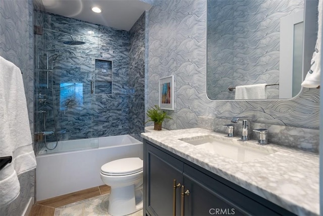 full bathroom with vanity, bathtub / shower combination, toilet, and wallpapered walls