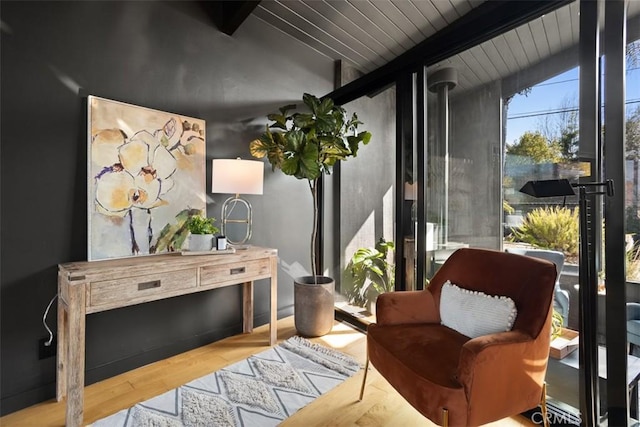 living area with vaulted ceiling with beams, wooden ceiling, and wood finished floors