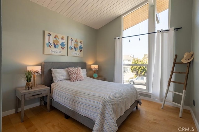 bedroom featuring light wood-type flooring, wood ceiling, lofted ceiling, and baseboards