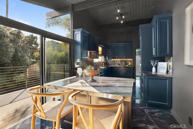 kitchen featuring tasteful backsplash, wood ceiling, blue cabinets, rail lighting, and a sink