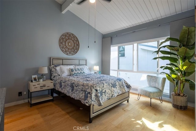 bedroom with high vaulted ceiling, light wood-type flooring, beam ceiling, and baseboards