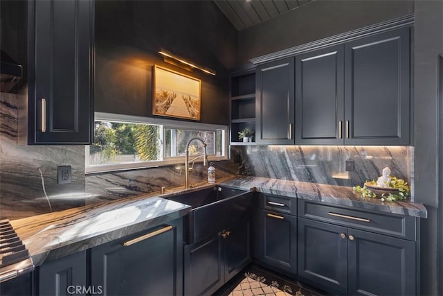 kitchen with open shelves, stone counters, a sink, and decorative backsplash