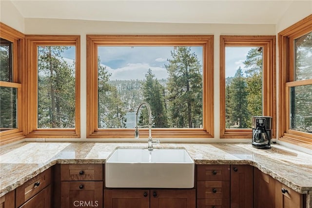 kitchen with light stone counters and a sink