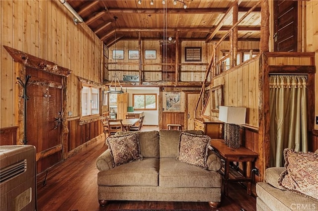 living room with wooden walls, wooden ceiling, wood-type flooring, stairway, and vaulted ceiling with beams