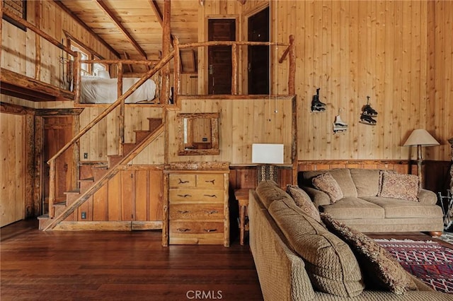 unfurnished living room with stairs, wood ceiling, wood walls, and wood finished floors