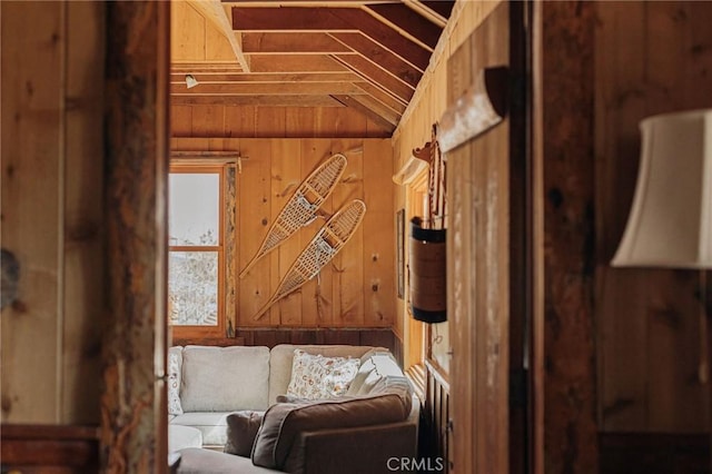 interior space with vaulted ceiling and wood walls