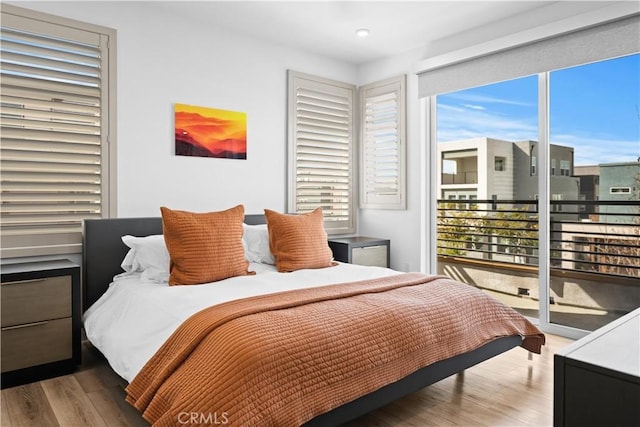 bedroom featuring access to outside and wood finished floors