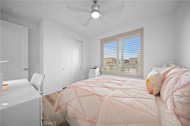 bedroom featuring light wood-type flooring, a closet, and ceiling fan