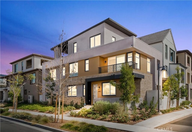 modern home featuring stone siding and stucco siding