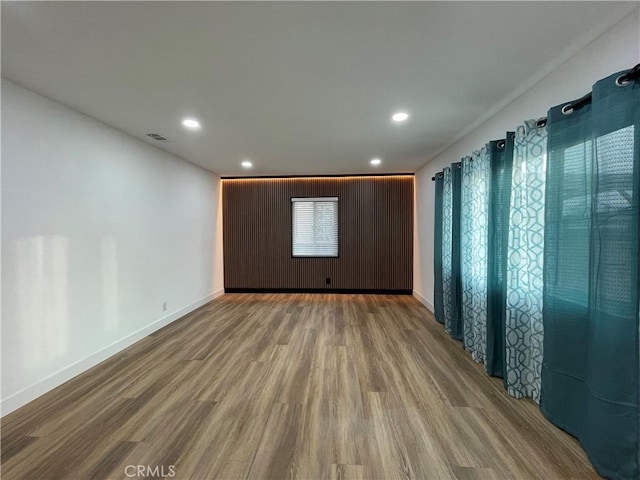 spare room featuring visible vents, recessed lighting, baseboards, and wood finished floors