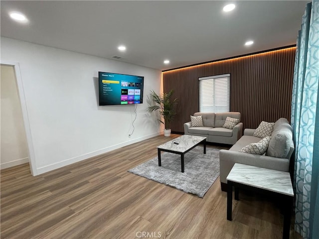 living room with recessed lighting, baseboards, and wood finished floors